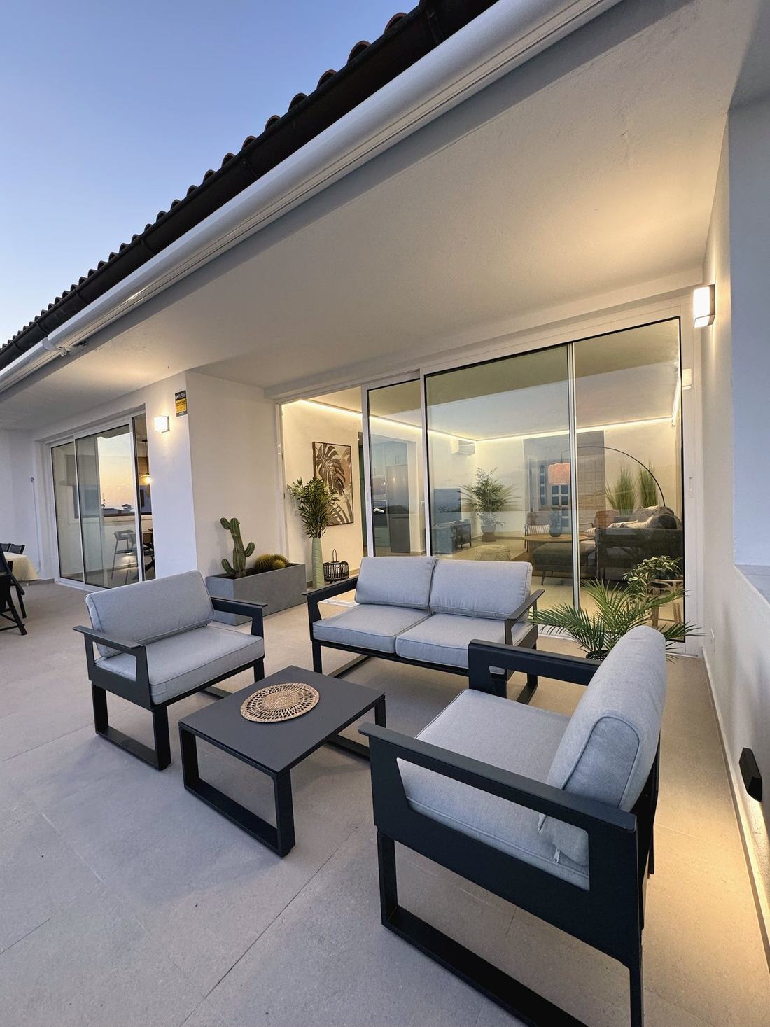 Terraza con sofás de exterior grises y vistas al atardecer